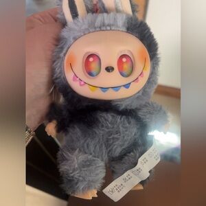 Popmart labubu the monsters secret
Gray and black Plush Toy with Colorful Face